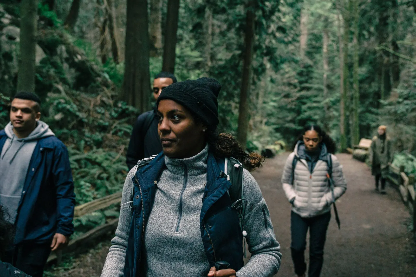 Un groupe de marcheurs avance sur un sentier en forêt