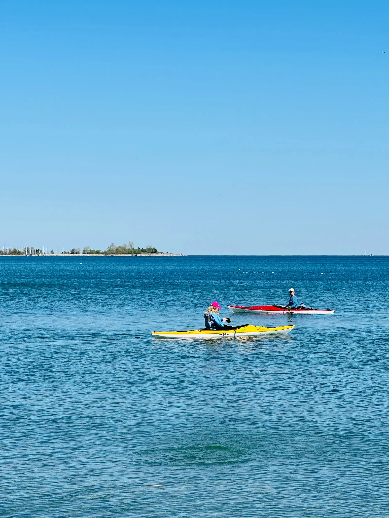 Deux kayakistes pagaient sur un plan d’eau ensoleillé